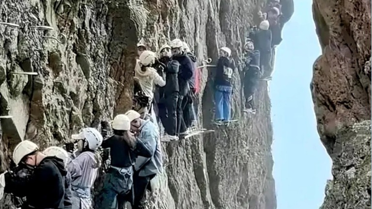 固定具を伝って登るクライミングルートで、混雑のため立往生する旅行客ら/Xiaohongshu