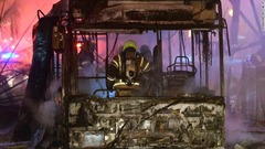 燃えるバスの消火を行う消防士＝１１日、イスラエル・ホロン