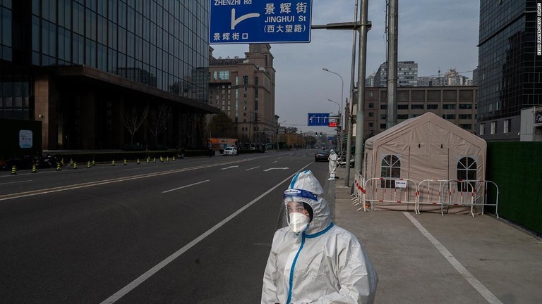 人通りがほぼなくなった北京のビジネス街に立つ感染規制対策の従事者/Kevin Frayer/Getty Images 