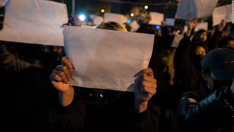 ゼロコロナ政策への抗議デモ参加者は検閲に抗議して白紙を掲げる＝２７日、北京/Kevin Frayer/Getty Images