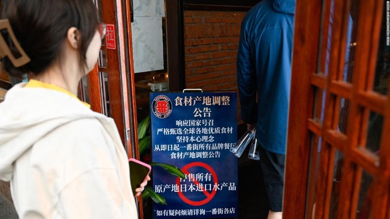 日本から輸入した魚介類の販売を一時停止することを伝える北京の日本料理店の看板/Pedro Pardo/AFP/Getty Images