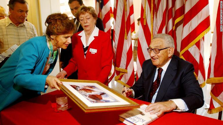 リチャード･ニクソン大統領図書館で自身の写真にサインするキッシンジャー氏/David McNew/Getty Images