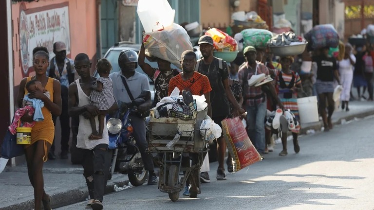 ハイチ首都ポルトープランスで警官とギャングが対峙する中、自宅から逃れる住民/Ralph Tedy Erol/Reuters