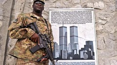 世界貿易センターのポスターの前に立つアフガン駐留米軍兵。ジャララバードの基地にて