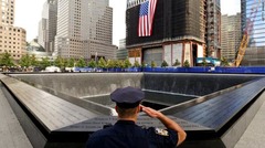 プール状の追悼施設に向かい敬礼するニューヨークの警官