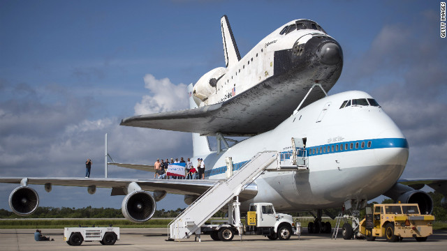 エンデバーを背に乗せたボーイング７４７型機の主翼上で記念写真をとる関係者