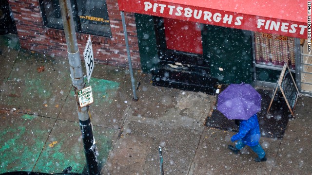 雪が降るなか傘をさす通行人＝２７日、ペンシルベニア州