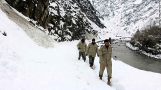 雪崩の被害を受けた地区へ調査に向かう人々＝パキスタン