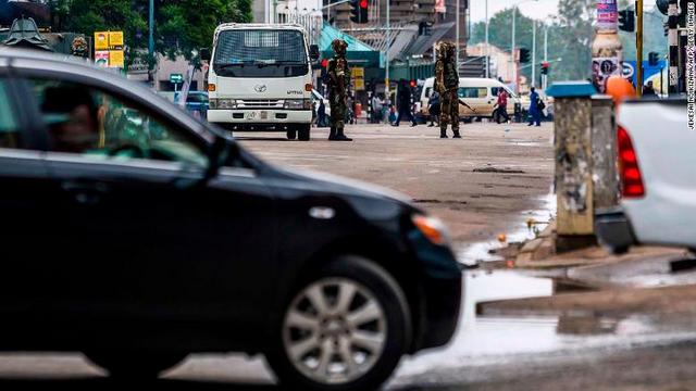 車両の流れに目を向ける兵士ら