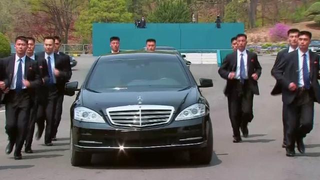 車両の周囲を並走する北朝鮮の治安要員