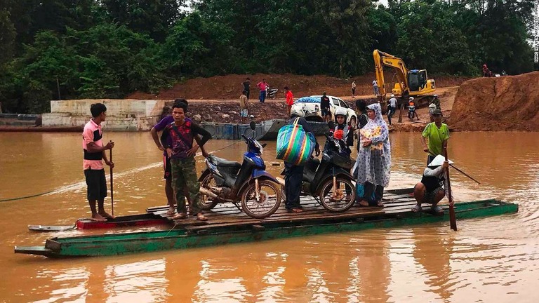 増水した川を即席のいかだで渡る人々/NHAC NGUYEN/AFP/Getty Images