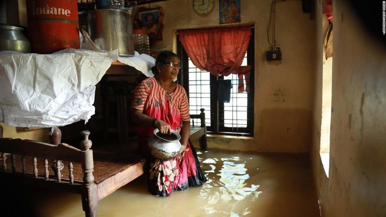 浸水した自宅の中で座る女性＝１０日、ケララ州/AFP/AFP/Getty Images