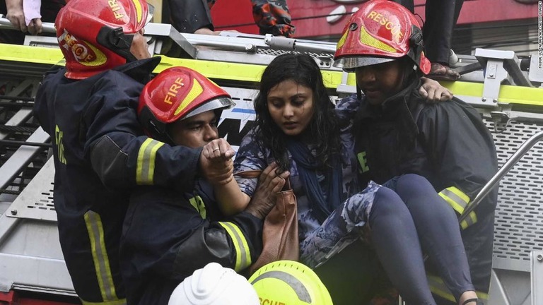 レスキュー隊によって救助される女性/MUNIR UZ ZAMAN/AFP/Getty Images