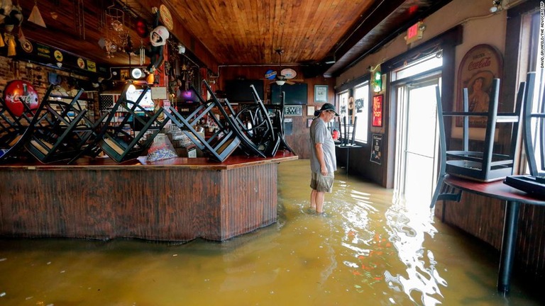 冠水した店内に立つ男性＝１３日/David Grunfeld/The Advocate/AP