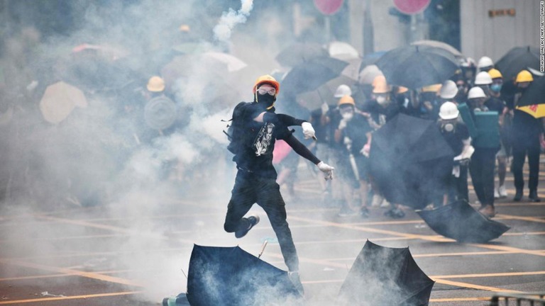 催涙ガスを投げ返すデモ参加者＝２７日、香港/ANTHONY WALLACE/AFP/Getty Images