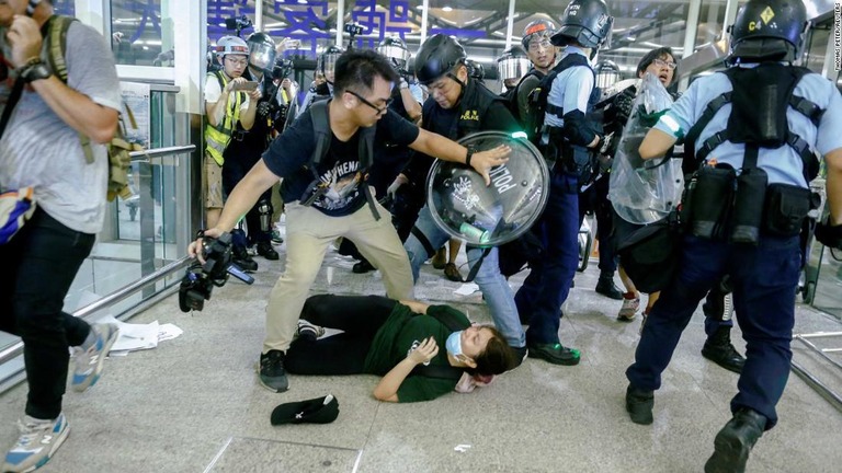 香港空港の占拠を続けるデモ隊と駆け付けた警官隊が衝突した/Thomas Peter/Reuters