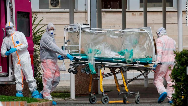 感染を防ぐストレッチャーで搬送される患者＝１７日、イタリア・ローマ/Alessandra Tarantino/AP
