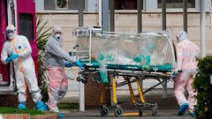 感染を防ぐストレッチャーで搬送される患者＝１７日、イタリア・ローマ