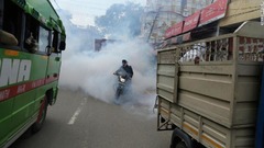 消毒剤の中を走るバイク＝１３日、インド