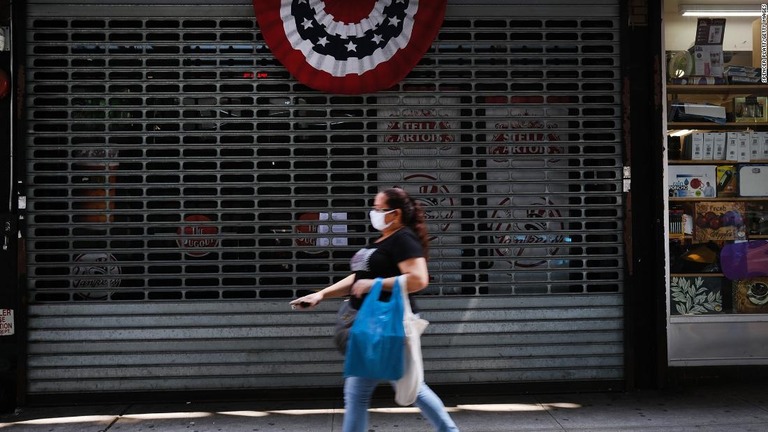 営業を中止した店の前を通る人＝２３日、米ニューヨーク市/Spencer Platt/Getty Images 