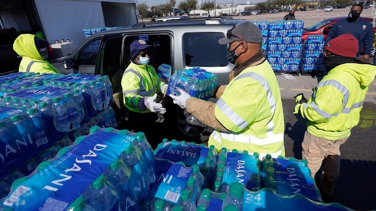 配送センターで車両に水を積み込む作業が行われる様子/David J. Phillip/AP