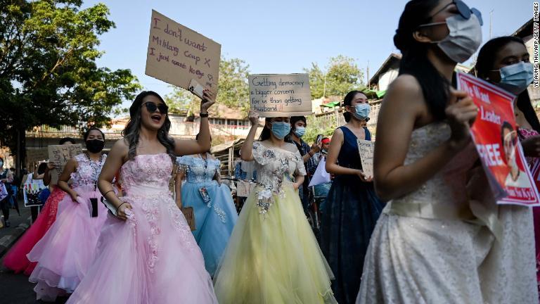 ウェディングドレスを着てプラカードを掲げて抗議デモに参加する女性たち＝２月１０日、ヤンゴン/Ye Aung Thu/AFP/Getty Images