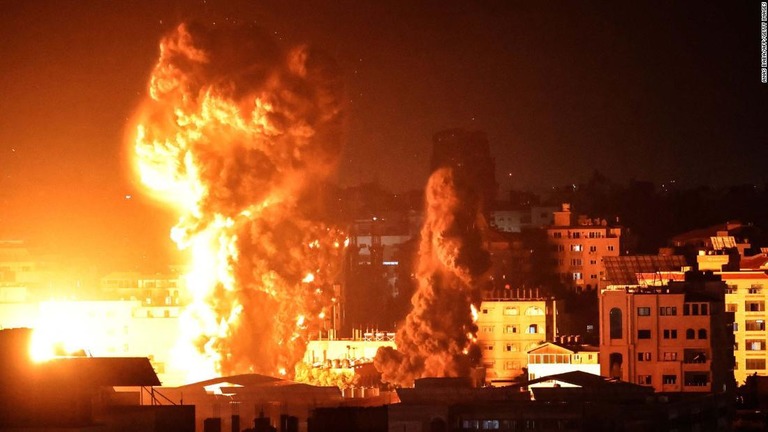 空爆を受けて炎と煙を巻き上げるガザ地区の建物/Anas Baba/AFP/Getty Images