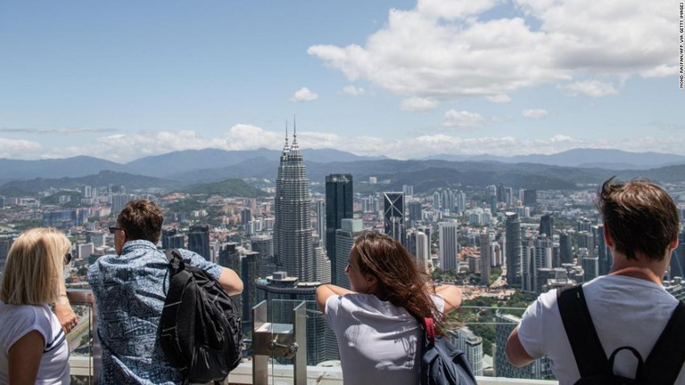 マレーシアの首都クアラルンプールの超高層ビル群を眺める観光客ら/Mohd Rasfan/AFP via Getty Images