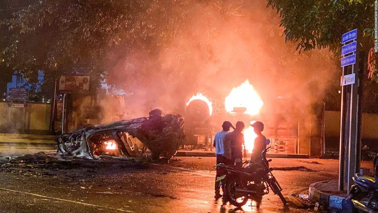 スリランカ首相の公邸付近で火を付けられ炎上する治安要員の車両とバス/Ishara S. Kodikara/AFP/Getty Images