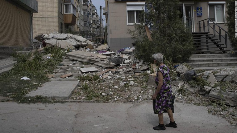 砲撃によって破損した建物を見る住民＝ウクライナ・ニコポリ/Metin Aktas/Anadolu Agency/Getty Images