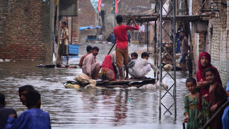 モンスーンの降雨後、住宅街の通りをいかだで移動する人々＝１９日、パキスタン・シンド州ハイデラバード
/AKRAM SHAHID/AFP via Getty Images