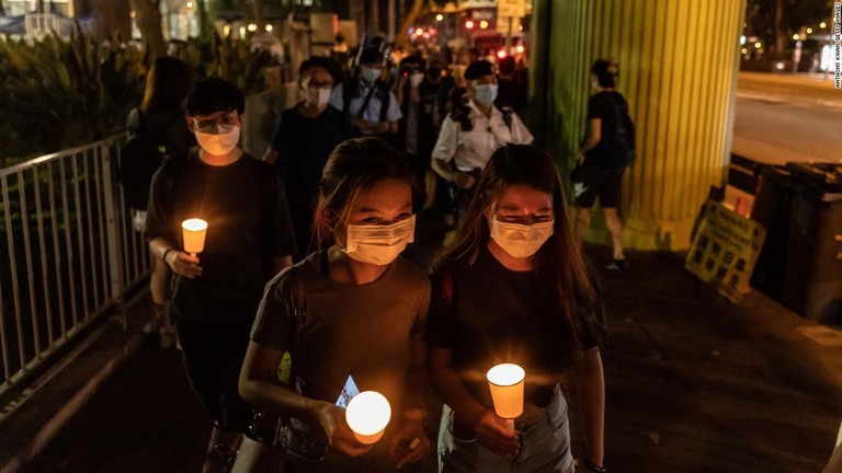 火を灯した蝋燭を手に、ビクトリアパークでの追悼集会に参加する人々/Anthony Kwan/Getty Images