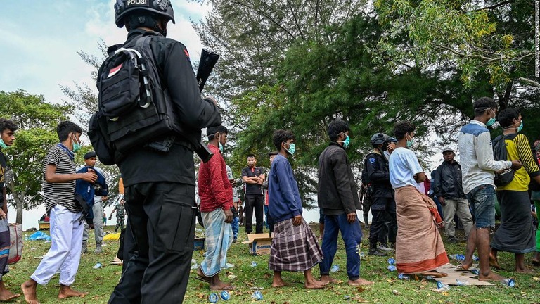 移送されるロヒンギャ難民を監視する警官＝２５日、インドネシア・アチェ州/Chaideer Mahyuddin/AFP/Getty Images