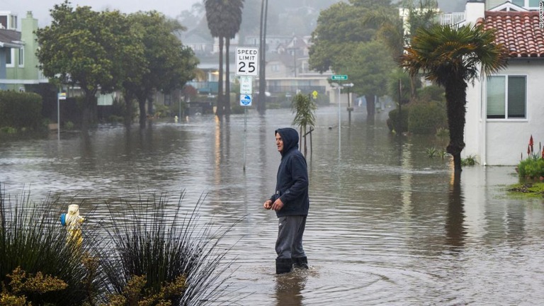 洪水に見舞われた道路を歩く男性＝米カリフォルニア州リオデルマール/Nic Coury/AP