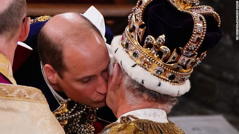 戴冠式で父王の頬に接吻するウィリアム皇太子/Yui Mok/Pool/AFP/Getty Images