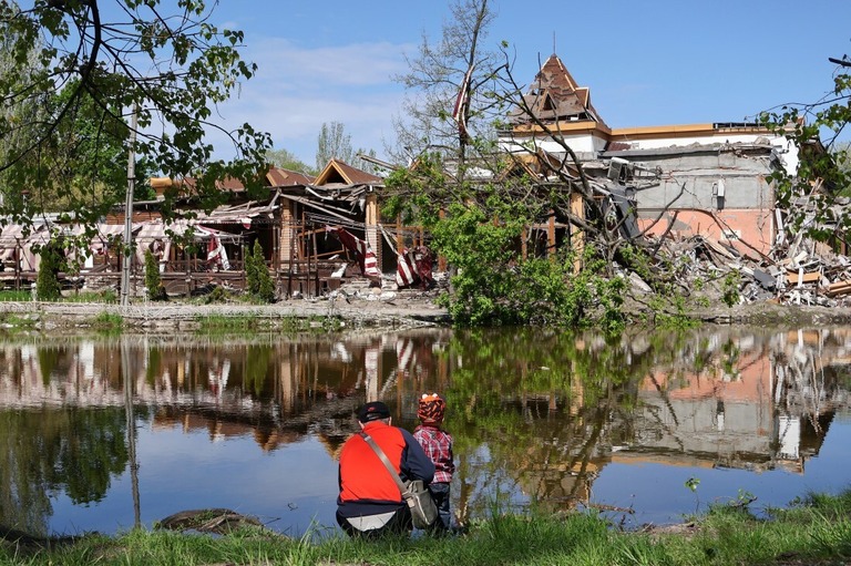 ロシアの砲撃後、子どもと一緒に破壊された建物を眺める男性＝ウクライナ・ザポリージャ州/Andriy Andriyenko/SOPA Images/LightRocket/Getty Images