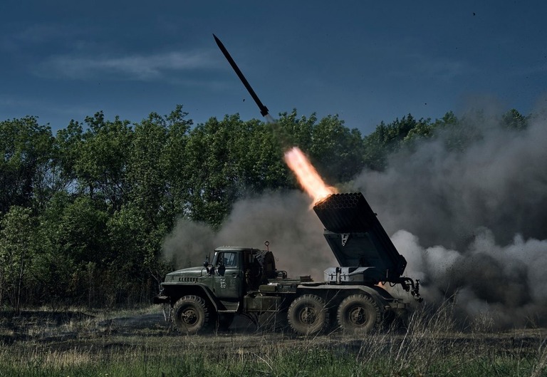 バフムート近くの前線でロシア軍の陣地に向けてロケット弾を発射するウクライナ軍/Libkos/AP