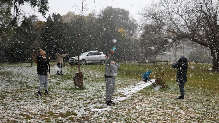 雪の写真をとる人たち＝１０日、南アフリカ・ヨハネルブルク/Wikus de Wet/AFP/Getty Images