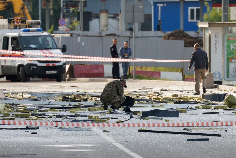 ドローン攻撃により損傷した建物を現場検証する治安当局員＝２４日、ロシア・モスクワ/ Maxim Shemetov/Reuters