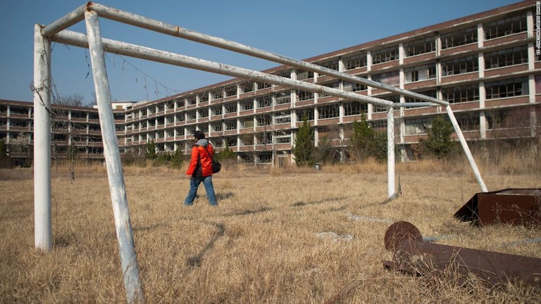 閉校した学校の敷地を歩く写真家/Ed Jones/AFP/Getty Images