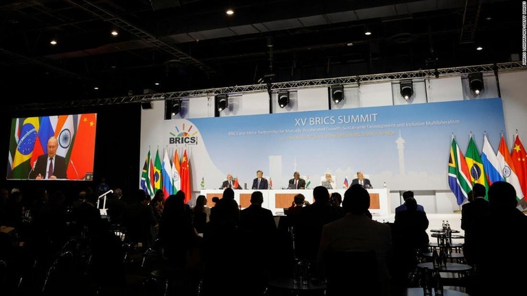 新興５カ国（ＢＲＩＣＳ）の首脳会議。演説を行うロシアのウラジーミル・プーチン大統領（写真左）がスクリーンに映されている＝２４日、南アフリカ・ヨハネスブルク/Marco Longari/AFP/Getty Images