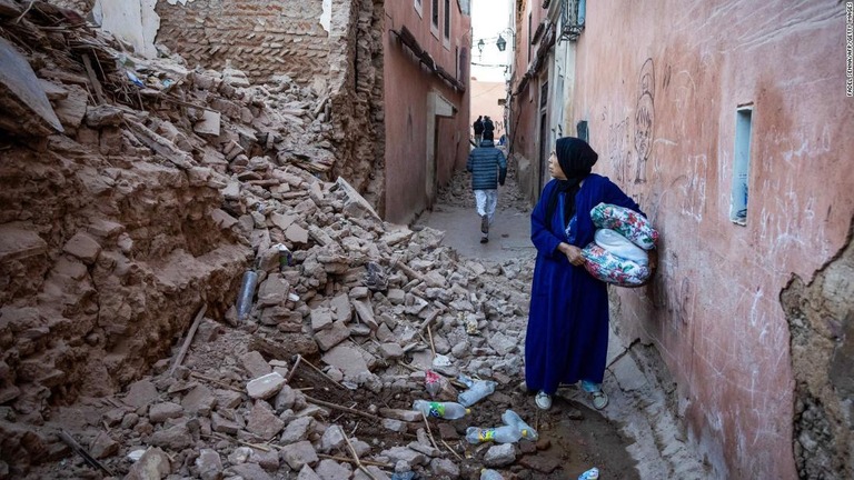 崩れた建物の横を歩く女性＝モロッコ・マラケシュ/Fadel Senna/AFP/Getty Images