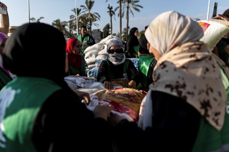 ガザへの支援トラックに食料や支援物資を積み込むボランティアの人々＝１６日、エジプト・北シナイ/Mahmoud Khaled/Getty Images