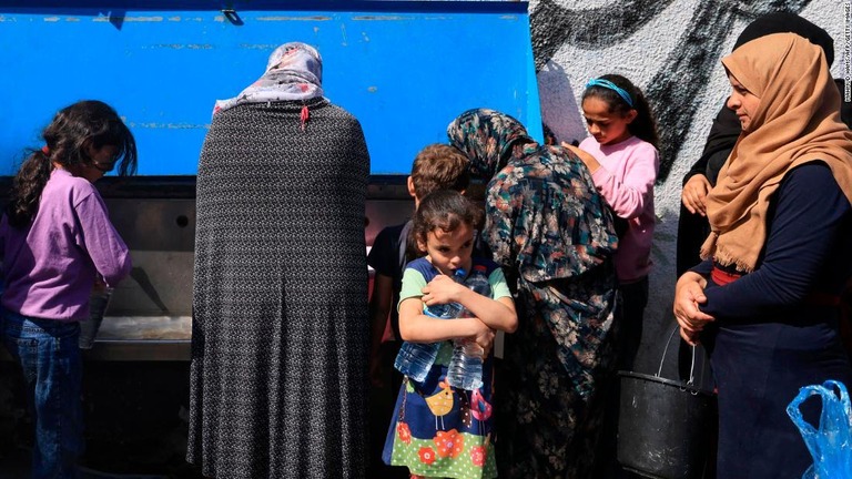 国連の施設で水を受け取る避難民＝２０日、パレスチナ自治区ガザ地区ハンユニス/Mahmud Hams/AFP/Getty Images