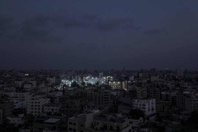 暗いガザの街並みで、病院にだけ明かりが灯る様子/Mohammed Saber/EPA-EFE/Shutterstock