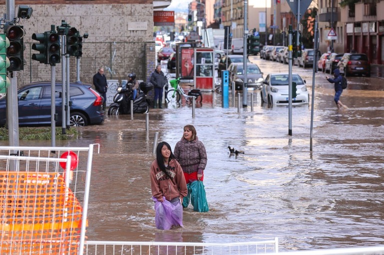 浸水した交差点を通る人々＝１０月３１日、イタリア・ミラノ/Vasile Mihai-Antonio/Getty Images