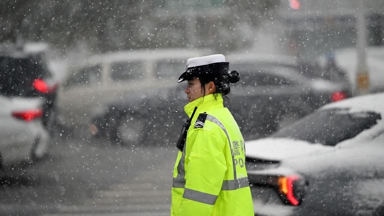 雪の中、車両に指示を出す警官＝６日、中国・遼寧省/CFOTO/Future Publishing/Getty Images