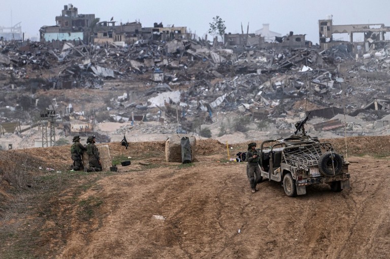 イスラエル軍の車両と兵士＝２３日、パレスチナ自治区ガザ地区南部の境界近郊/Tsafrir Abayov/AP