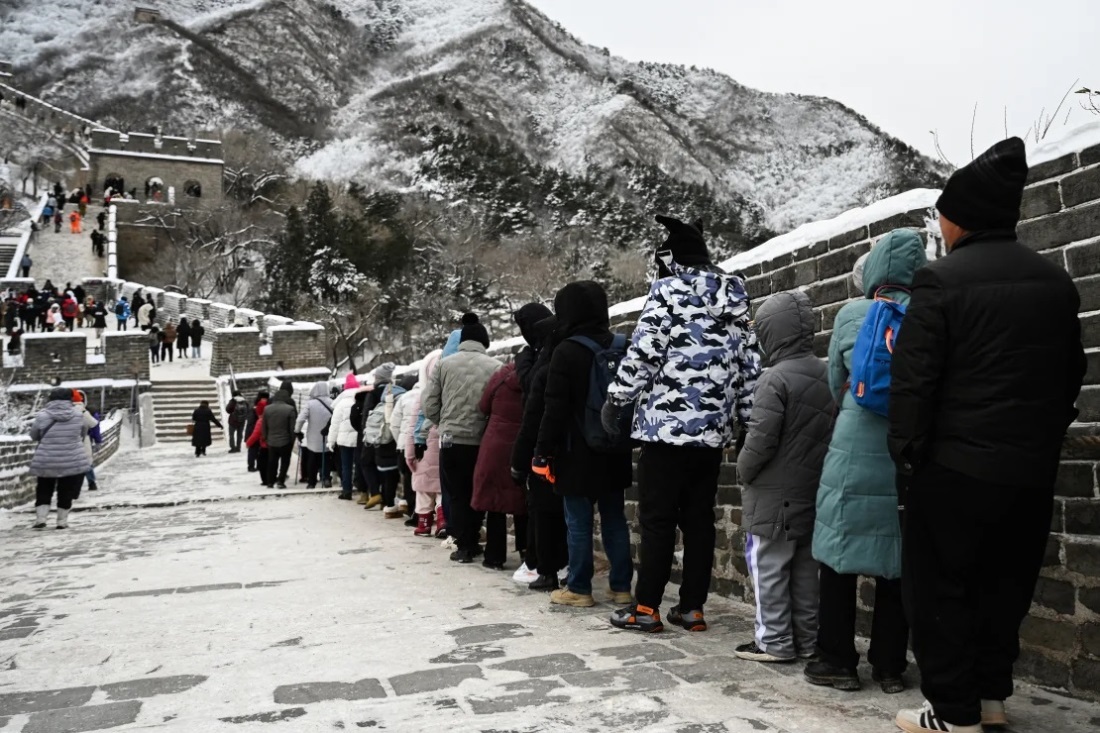 降雪のため、万里の長城での移動にロープを使う人たち/Greg Baker/AFP/Getty Images