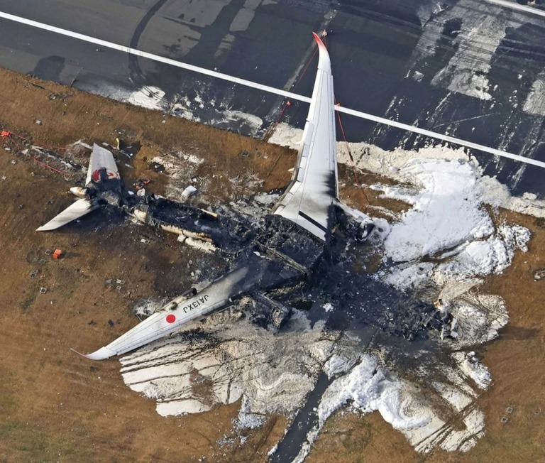 羽田空港着陸後に海保機と衝突し、炎上した日本航空機の残骸/Kyodo News/AP